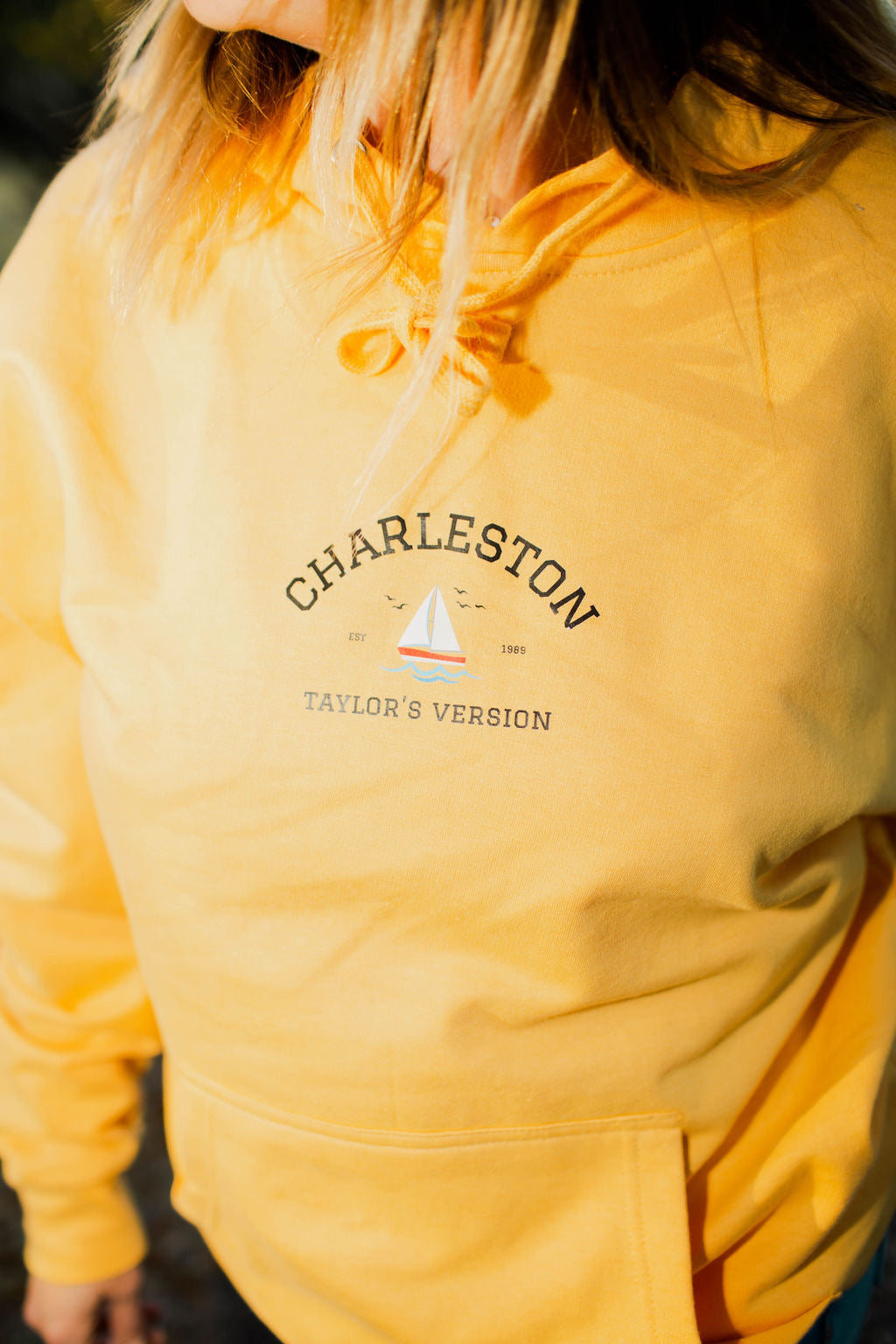 long sleeve mustard yellow hoodie, 6 inch printed graphic depicts the words "CHARLESTON TAYLORS VERSION"